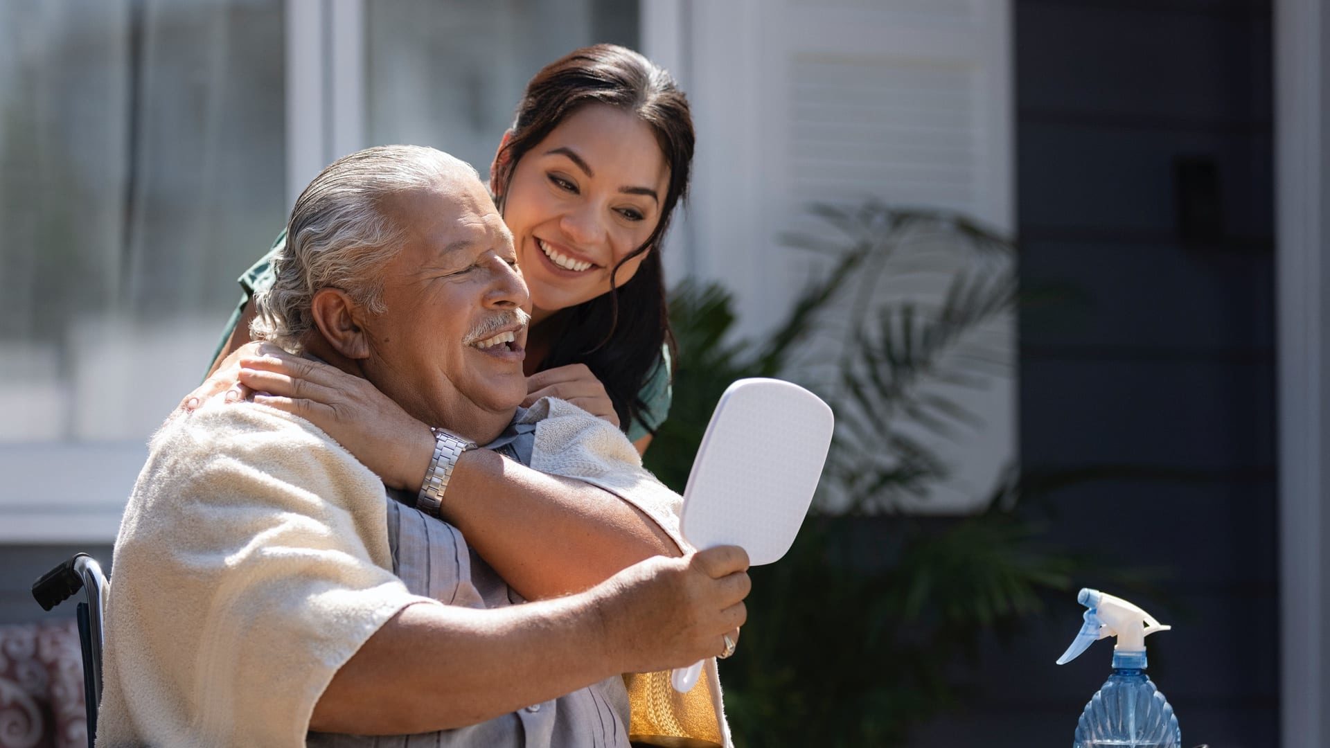 Man and woman smiling as they look in a mirror.